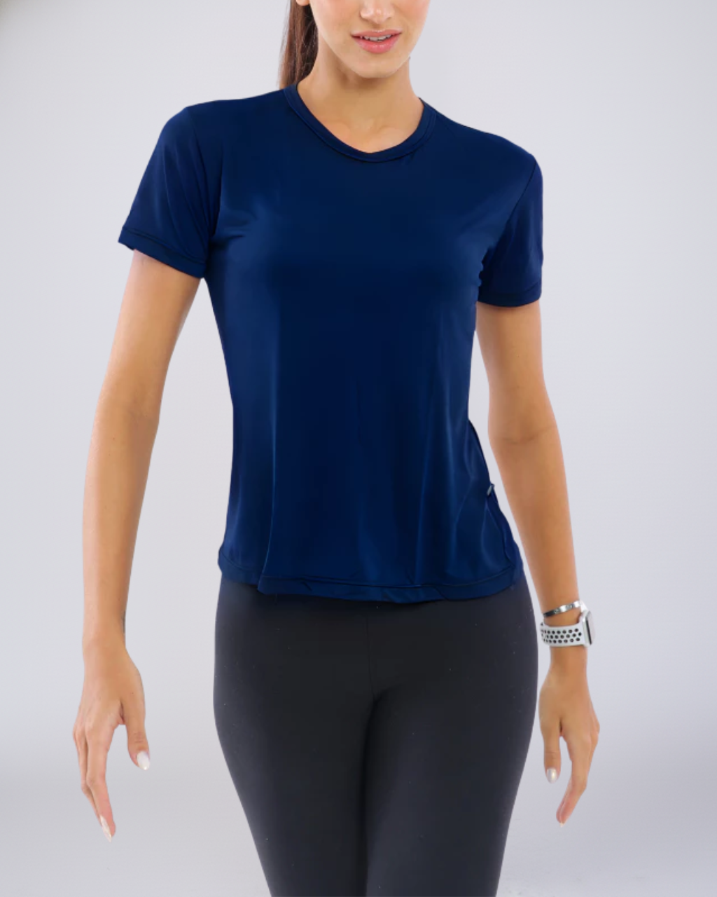 Mulher vestindo Camiseta Baby Look Dry Fit azul-marinho. Peça fitness de performance com tecido respirável e toque premium, ideal para treinos e academia