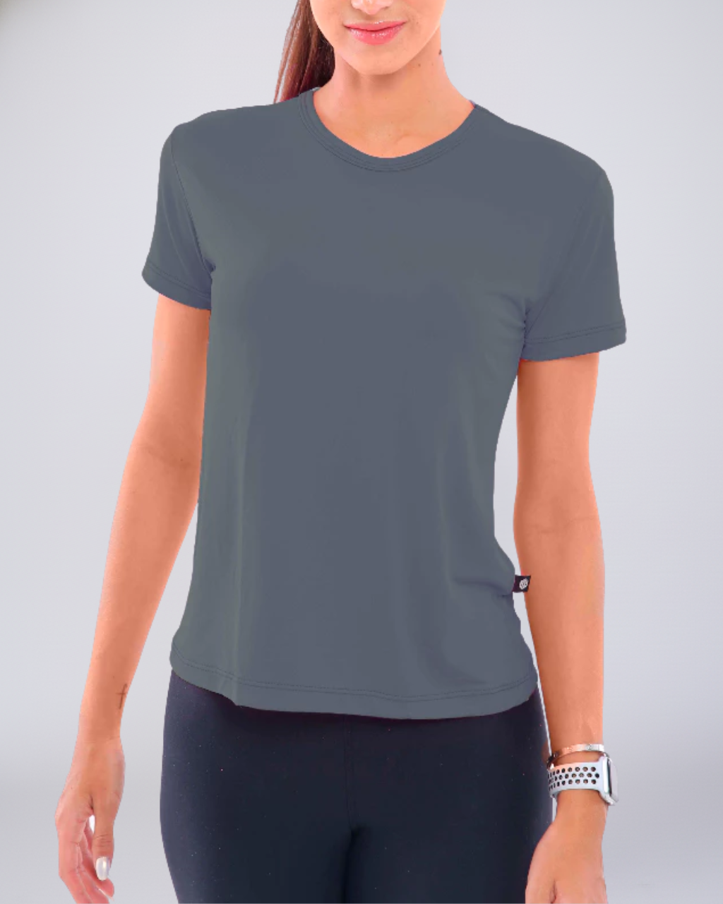 Mulher vestindo Camiseta Baby Look Dry Fit chumbo. Essencial de moda fitness premium, ideal para treinos de alta intensidade. Conforto, caimento e tecnologia Dry Fit superior.