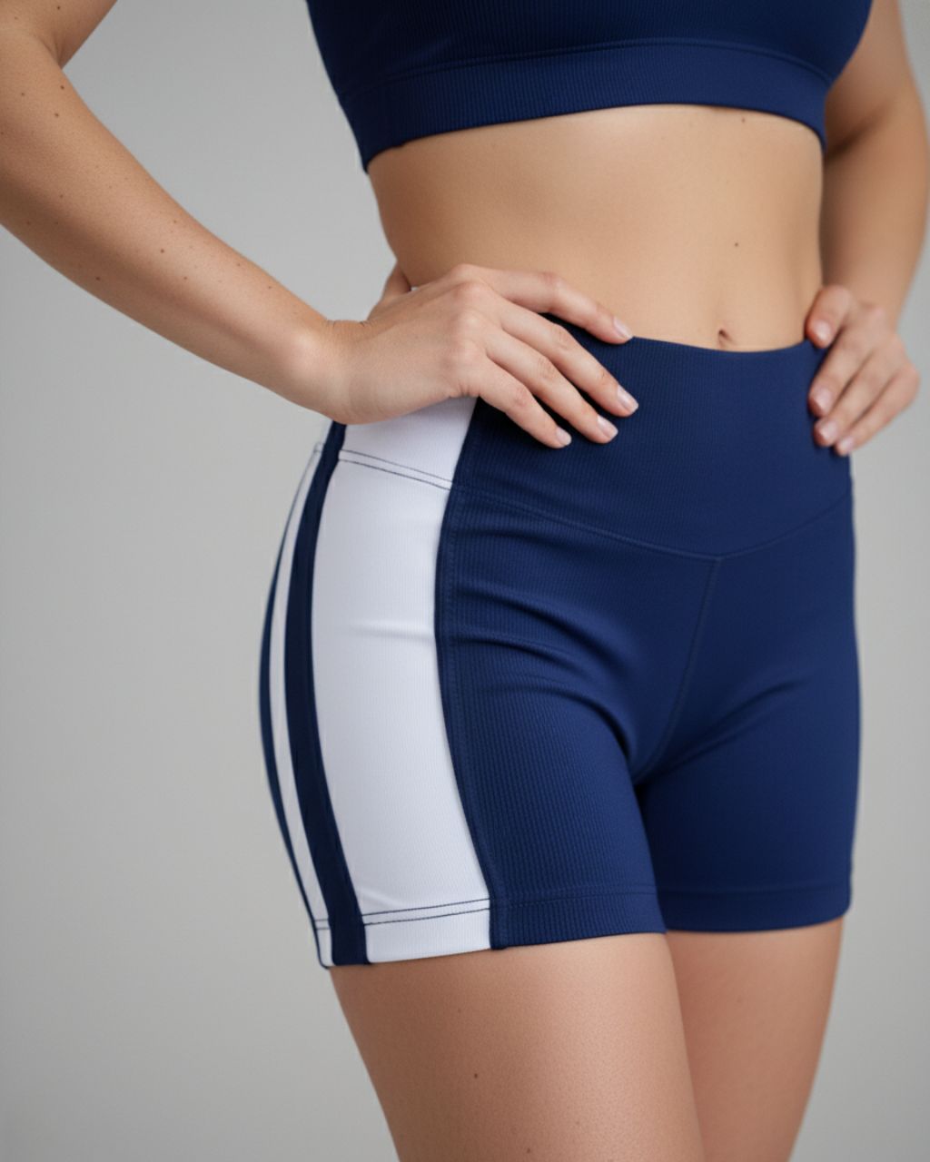 Close do Short Urban Flow da Lojas Dourado em tecido azul-marinho com faixas brancas. Imagem destaca cintura alta, compressão média e acabamento impecável do tecido canelado.