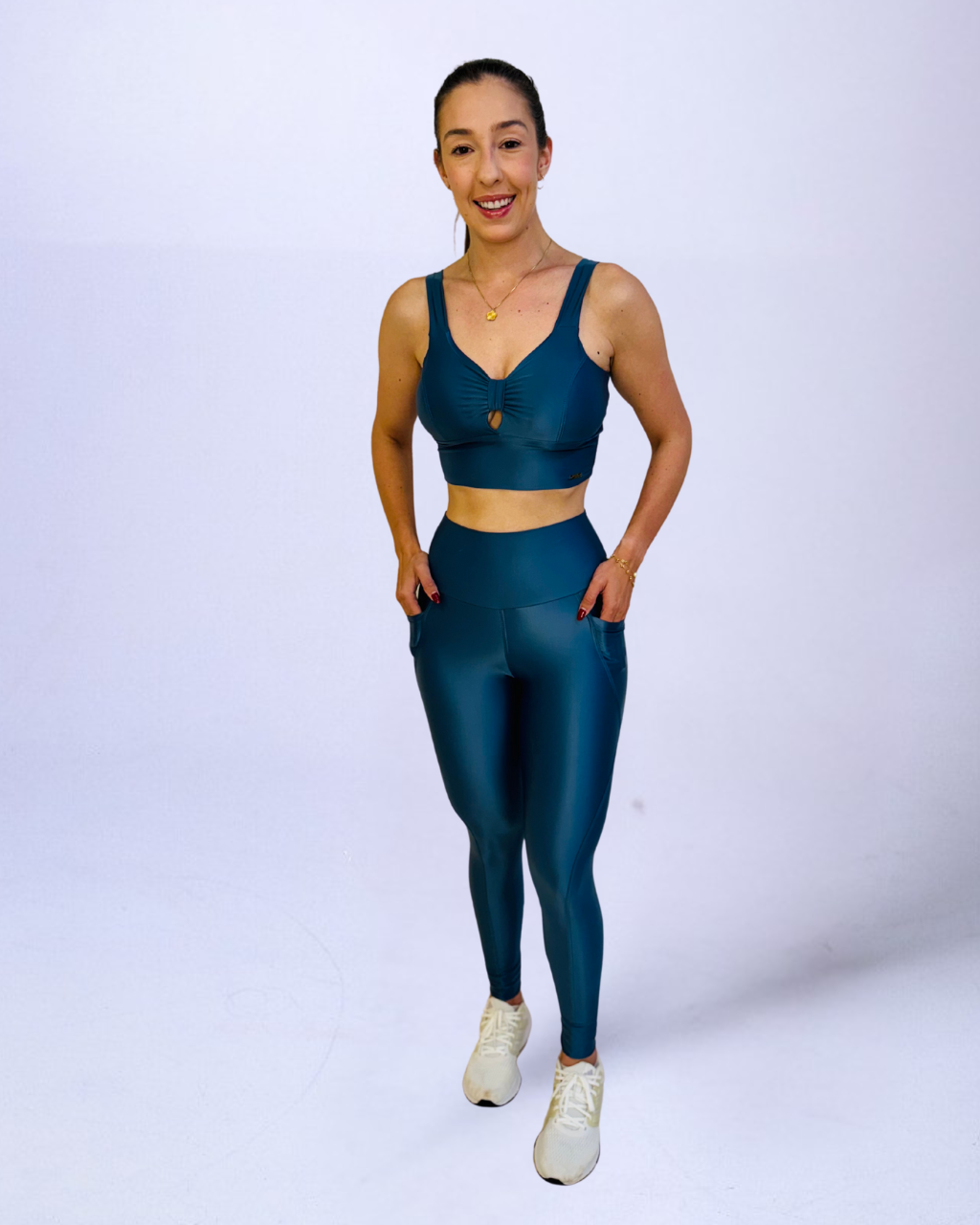 Conjunto fitness feminino azul petróleo brilhante com legging de cós alto e top esportivo franzido. Ideal para academia, yoga e treinos, oferece conforto e estilo.