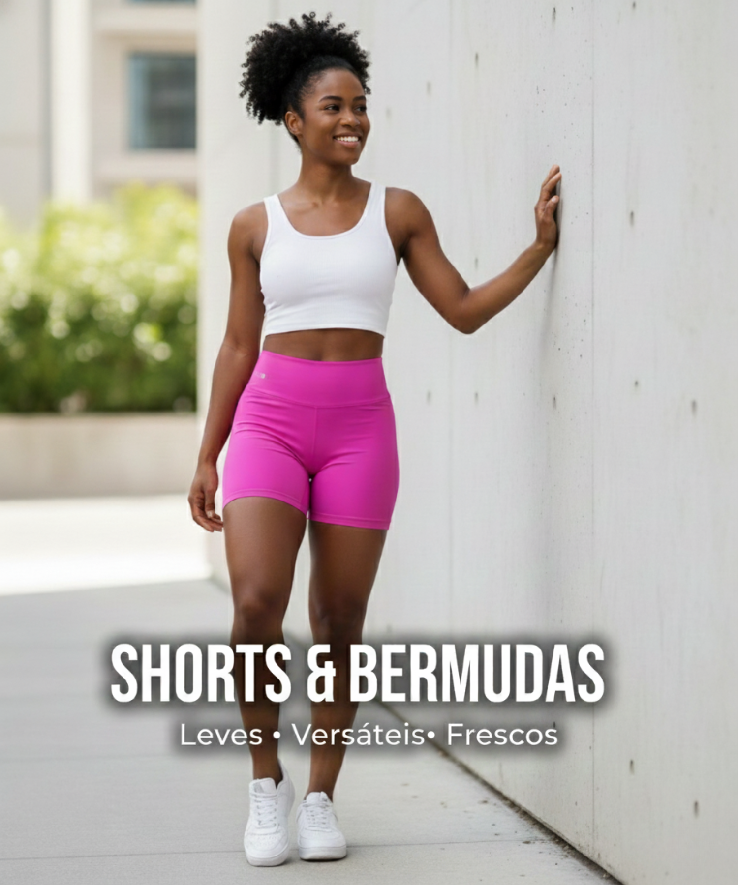 Mulher vestindo shorts rosa fitness e regata branca, em ambiente urbano, destacando leveza, versatilidade e frescor para treinos e lazer.